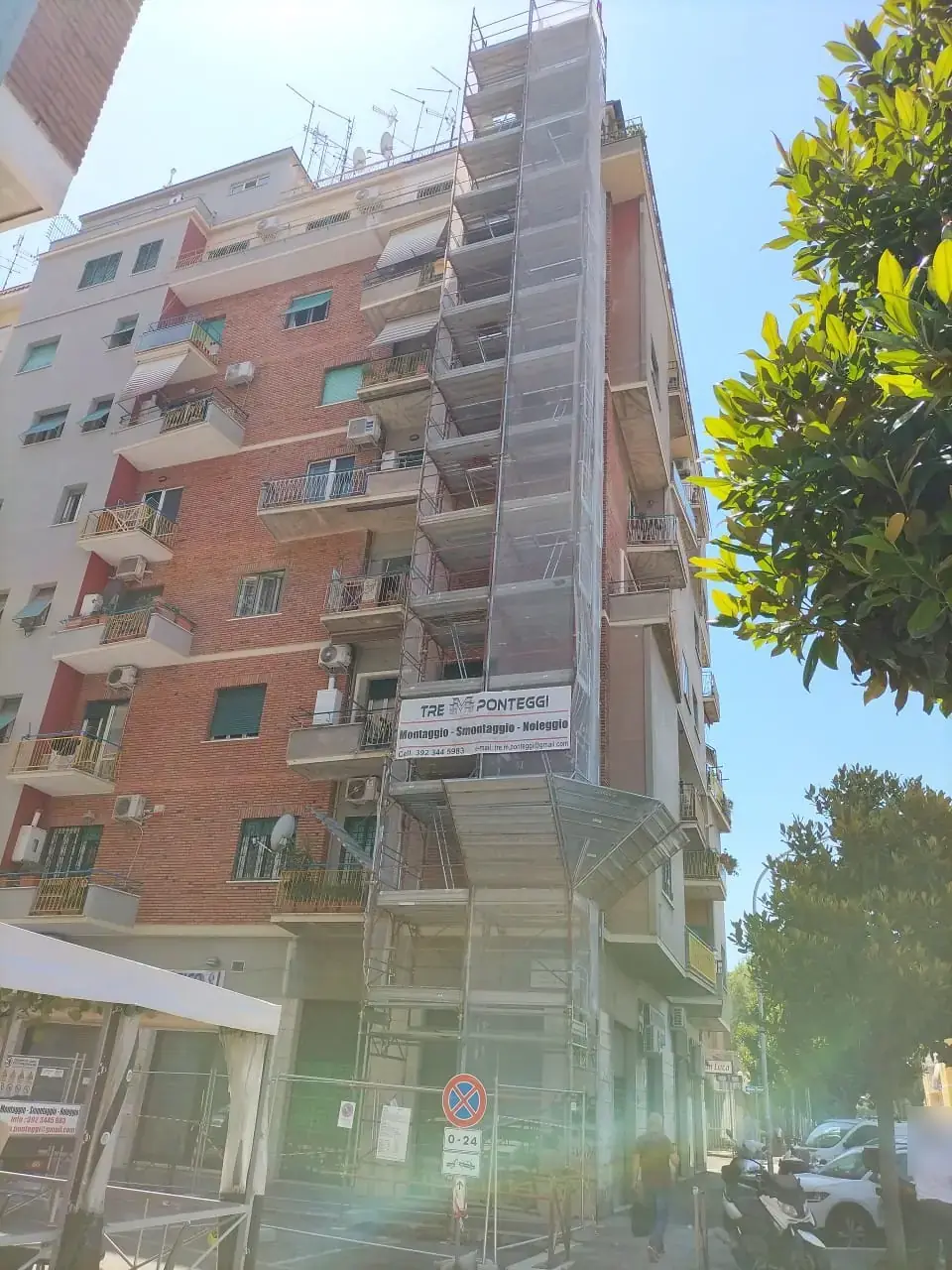 Torre di ponteggio lungo un palazzo in mattoni in una via di Roma