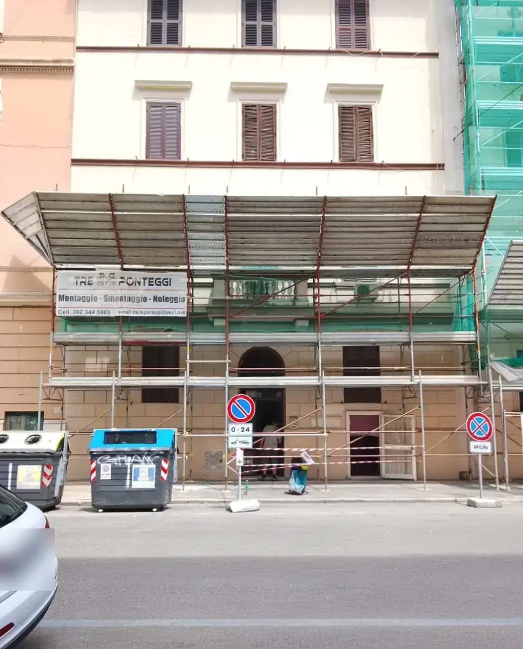 Ponteggio con tunnel pedonale coperto davanti al portone di un palazzo su strada
